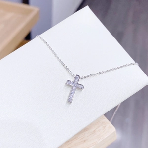 Detalle del collar con cruz de plata y circonitas sobre tarjeta de joyería