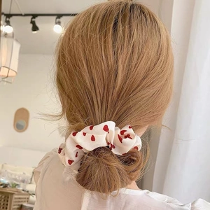 White scrunchie with red heart pattern shown on hair from a back view perspective