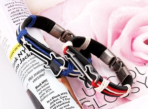 Detailed macro of woven leather bracelets with silver guitar charms on floral background