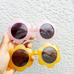 Pink and yellow flower shaped sunglasses for kids with round dark protective lenses
