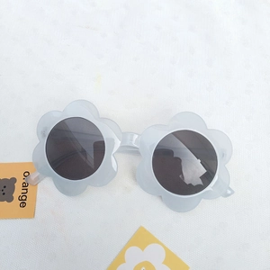 Detailed top view of flower-shaped children's sunglasses with matte light grey frames