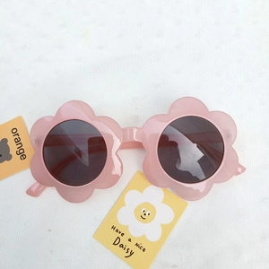 Detailed close-up of pink flower-shaped toddler sunglasses with dark protective lenses