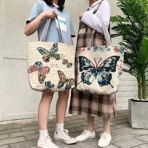 Detail view of ethnic canvas tote bag with butterfly prints and striped handles