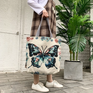 Detailed texture of canvas tote bag featuring a blue butterfly and floral pattern