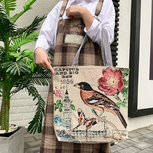 Detail of vintage canvas tote bag with floral patterns and striped shoulder strap