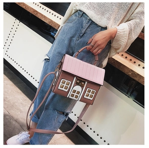 Detailed view of creative house-shaped crossbody bag worn by a model in casual outfit