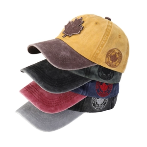Close-up of assorted maple leaf baseball caps showing textured washed cotton and CANADA embroidery