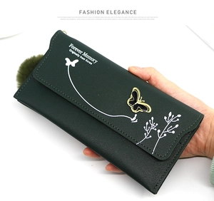 Detail of dark green long wallet with butterfly hardware and litchi grain texture