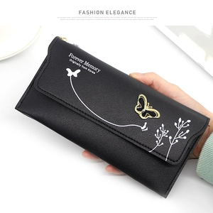 Detail of black pebbled leather long wallet featuring white floral prints and butterfly charm