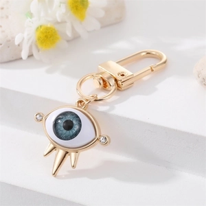 Detail of blue evil eye keychain with gold metal frame and sparkling crystal accents