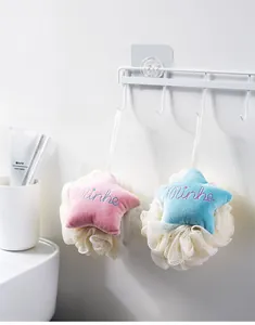 Detail of star-shaped bath sponges in pink and blue hanging in a bathroom setting