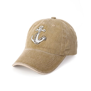 Close-up of white anchor embroidery on washed denim cotton mustard yellow baseball cap