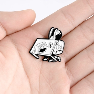 Black and white enamel pin showing a tired girl stretching at her office desk