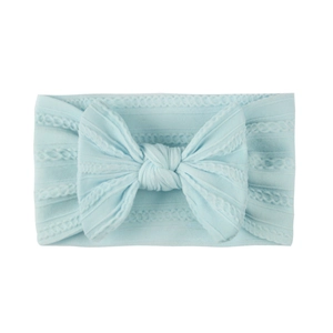Detail of light blue jacquard nylon baby headband featuring a soft knit texture and bow