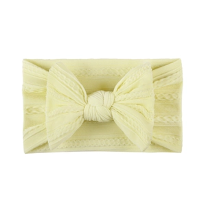 Detail of soft yellow jacquard nylon baby headband with textured cable knit bow
