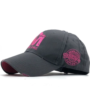 Détail d'une casquette gris foncé avec broderie M EXPLORE rose et bordure effet usé