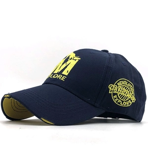 Détail de casquette en coton bleu marine avec broderie M et visière à effet usé