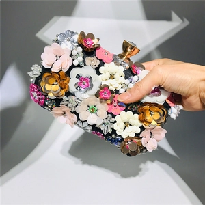 Detail of 3D handmade floral petals and colorful sequins on luxury evening clutch bag