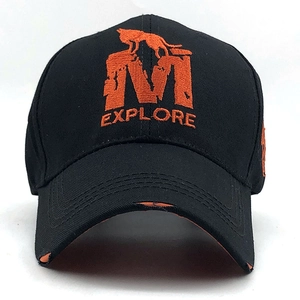 Détail d'une casquette noire avec broderie loup orange et visière à effet usé tendance