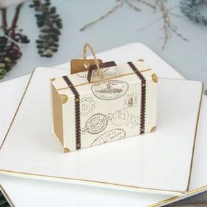 Macro view of vintage suitcase style paper gift box with twine handle and postal print