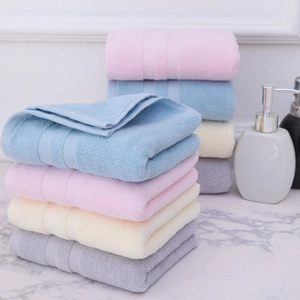 Serviettes épaisses en coton de couleurs pastel empilées sur un plan de salle de bain