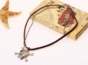 Detail of layered skull pendant necklace with leather cord and beaded metal chain