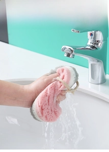 Detail van de drielaagse badspons die zacht wordt onder de lopende waterkraan