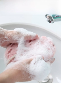 Detail van roze douche spons met hoge dichtheid die rijk schuim en ophangkoord toont