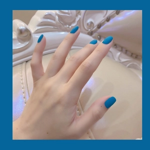 Matte kobaltblaue Kunstnägel zum Aufkleben mit solidem Frost-Finish auf der Hand