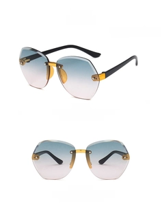 Detail of rimless polygon kids sunglasses with gradient green to pink lenses and gold bridge