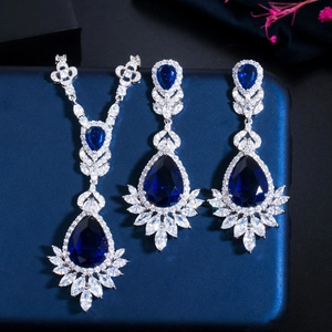 Macro detail of silver bridal necklace and earrings with pear-cut deep blue gemstones