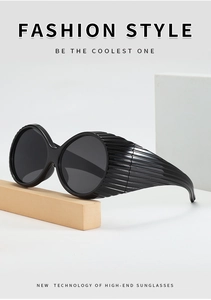 Detail view of fashion oversized round sunglasses featuring wide textured temples and dark lenses
