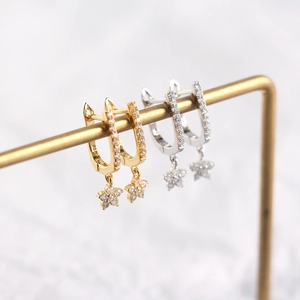 Detail of S925 sterling silver U-shaped hoop earrings with zircon star charms in gold and silver