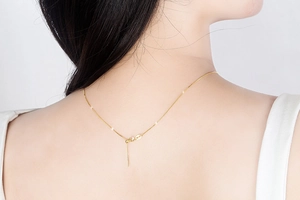 Close-up of adjustable gold s925 silver chain necklace on a model neck back view