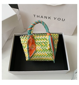 Close-up of hand-woven colorful beach bag in premium gift box with scarf-wrapped handle