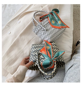 Close-up of geometric woven tote bag featuring decorative floral scarf on handle
