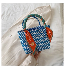 Detail view of woven blue and white checkered handbag with decorative Peace silk scarf handle