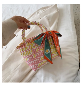 Close-up of colorful woven basket bag with patterned ribbon detail and top handles