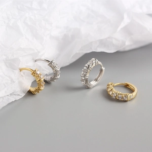 Close-up of gold and silver S925 sterling silver geometric hoop earrings with pavé diamonds
