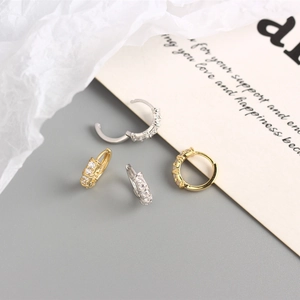 Gros plan de boucles d'oreilles créoles en argent S925 doré et argenté avec zircons