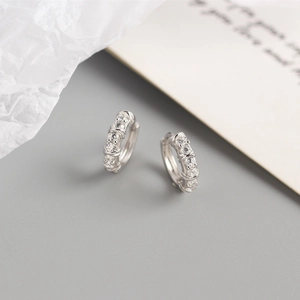 Vue détaillée des boucles d'oreilles huggie en argent S925 avec pavé de zircons brillants