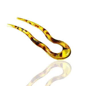 Detail of tortoiseshell resin U-shaped hair fork with elegant amber mottled texture