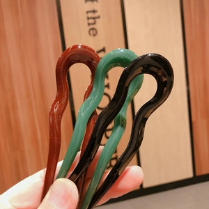 Three wavy resin U-shaped hair pins in brown, green, and black for elegant updos