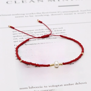 Bohemian adjustable red beaded bracelet with a natural pearl accent and gold metal spacers