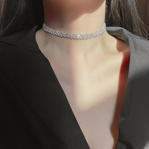 Sparkling silver choker necklace with geometric rhinestone inlay worn by a model