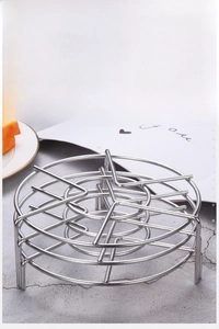 Macro detail of a 304 stainless steel steaming rack with three sturdy support legs