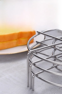 Detailed view of stacked stainless steel steaming racks with smooth edges on marble