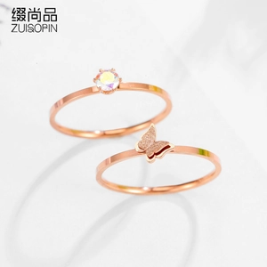 Macro view of rose gold butterfly rings with sparkling crystal on marble background