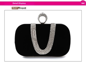 Detailed macro of black velvet evening clutch with ring clasp and rhinestone tassels