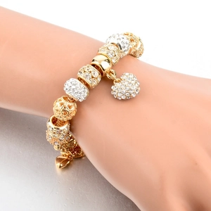Detailed close-up of a gold-plated snake chain bracelet with sparkling rhinestone charms